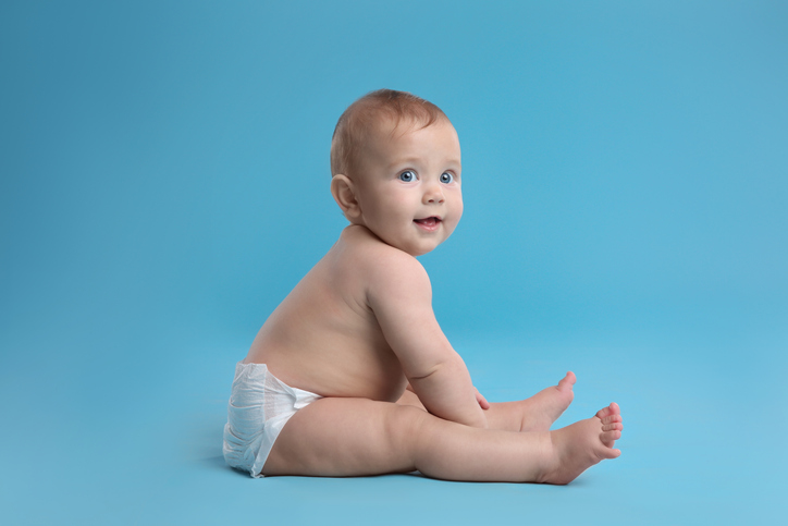 Cute Baby In Dry Soft Diaper Sitting On Light Blue Background - The Role Of Emotion In Advertising
