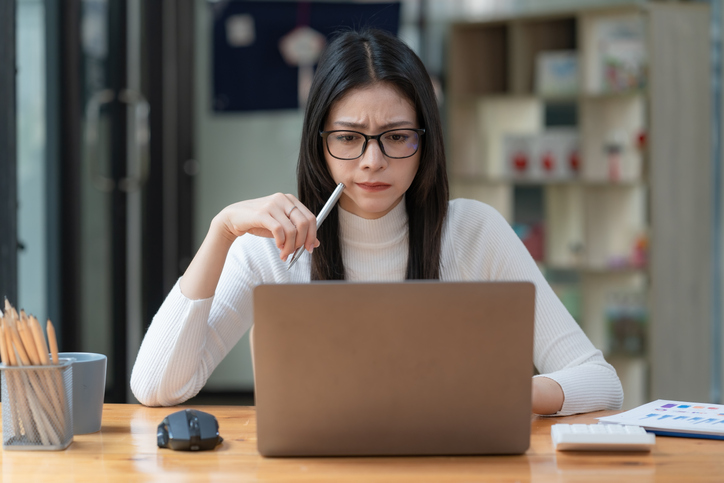 Concerned Female Worker Looking At Laptop Screen Suspiciously, Thinking About Problem Solving, Reading Ambiguous Emai...
